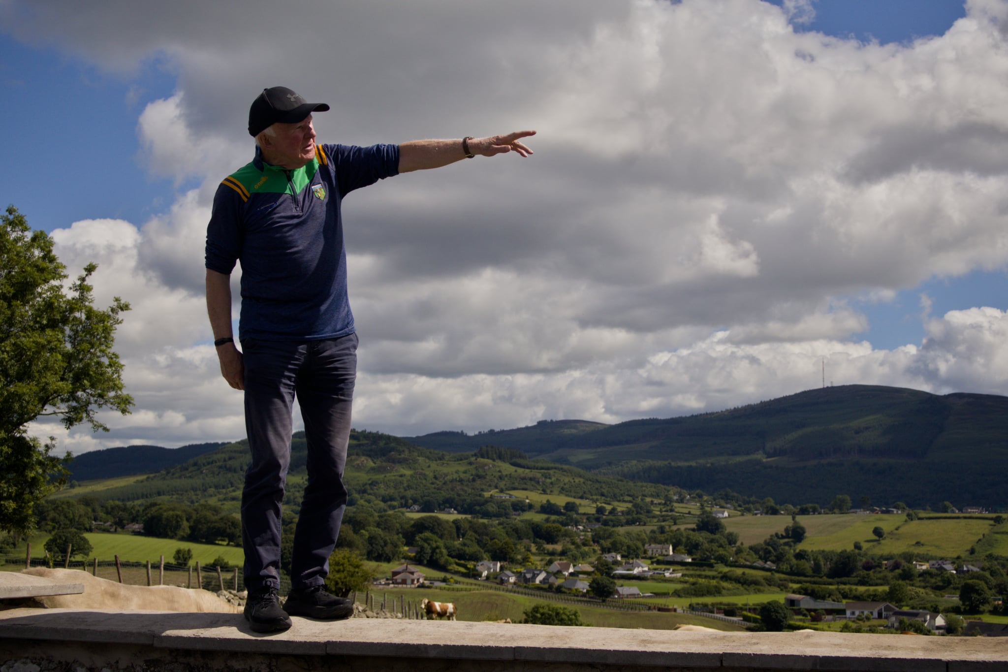 A man pointing out across the landscape